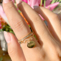 Anel cravejado com zircônias brancas pingente love banho ouro 18k.