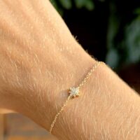 Pulseira com  estrela pequena cravejada com zircônias brancas  em banho ouro 18k .