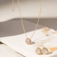 Conjunto redondo cravejado com zircônias brancas em banho ouro 18k.