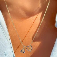Escapulário coração e nossa senhora cravejado com zircônias azuis em banho ouro 18k.