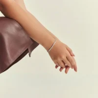 Pulseira com fileira curva cravejada com zircônias em ródio prata.